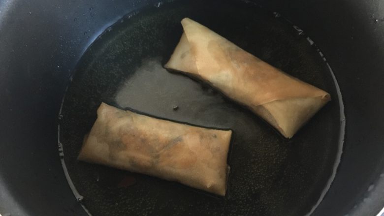 炸春卷(少油版),将春卷慢慢炸至金黄色捞出沥干油分,装盘就可以开动啦。