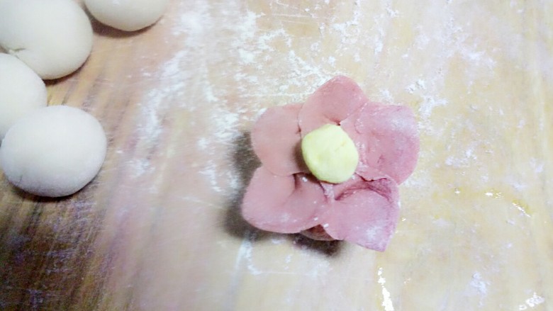 吃掉一朵花+小花馒头,取一块南瓜面团,揉圆,蘸点水放在花芯上