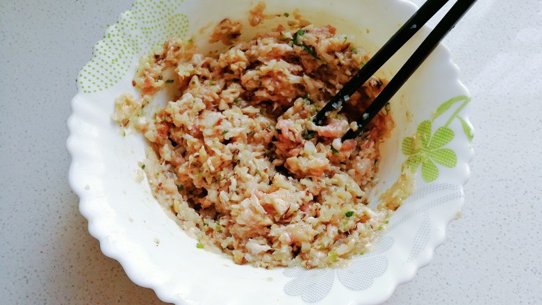 香菇肉包子,然后翻拌均匀,用筷子顺着一个方向搅打上劲,香菇肉馅就做好啦;
