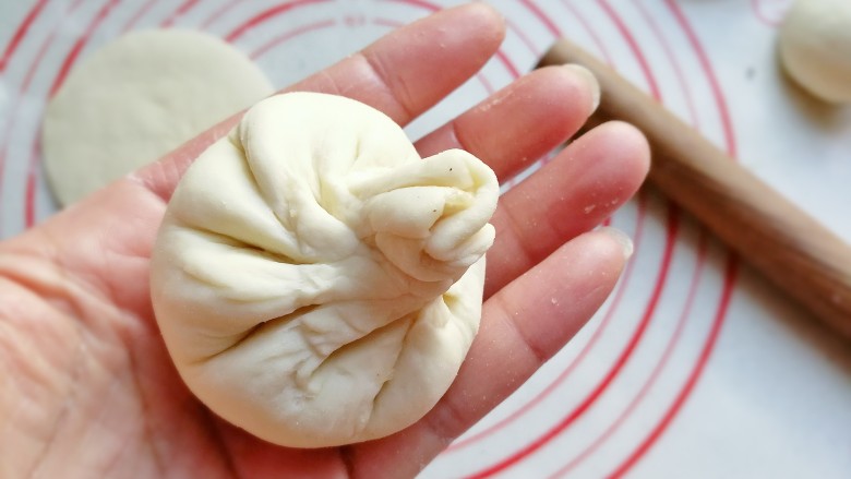 香菇肉包子,接着像包包子一样捏皱折捏起来,所不同的是皱折要捏稀疏一点,捏的时候尽量把面皮向上提拉,形成一个小揪揪,再把小揪揪捏紧就是香菇蒂啦;