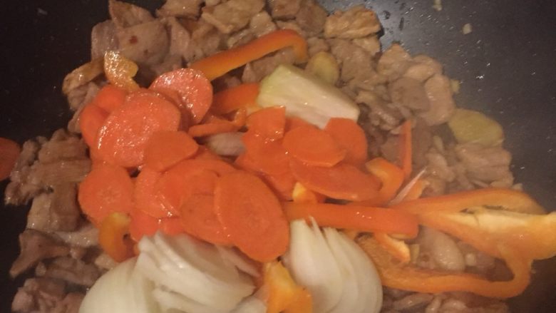 另类回锅肉,加入彩椒、洋葱和过了油的胡萝卜一起从容翻炒,直至酱汁完全被吸收入菜中。