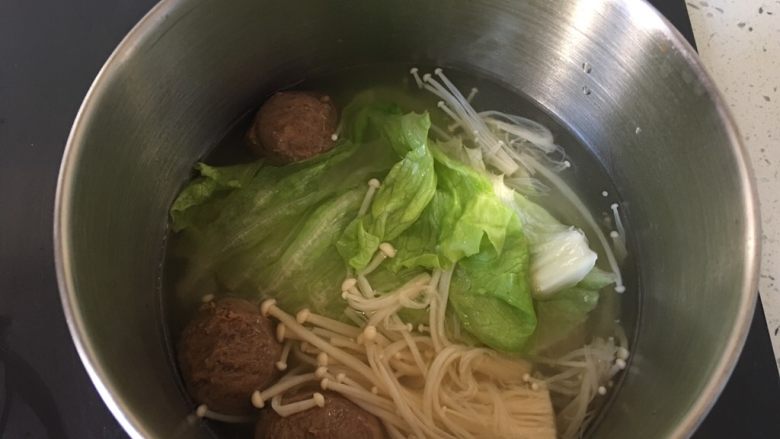 豪华版螺狮粉,另起一锅将牛丸先煮几分钟,然后加入金针菇煮一分钟,最后加入生菜关火。