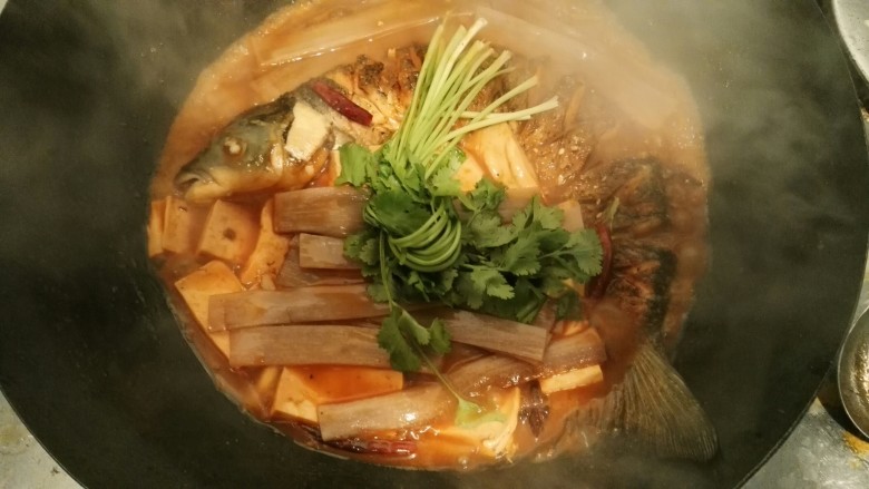 东北得莫利炖鱼,加粉条,豆腐,香菜节盖锅盖小火在闷十分钟左右开大火收汁。