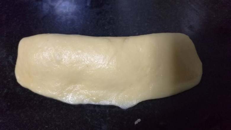 面包入门基本功之黄油面包卷,再对折,用掌根按牢接缝处。