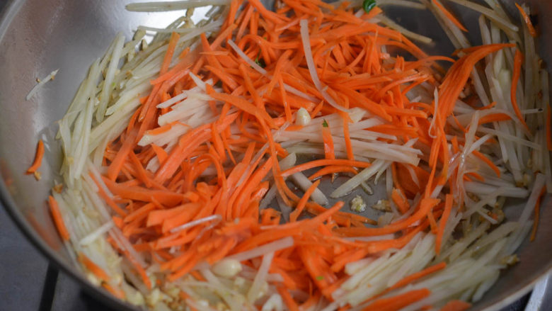 蒜蓉胡萝卜土豆丝,很好吃的素菜,下胡萝卜土豆丝翻炒。