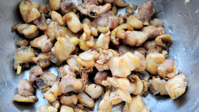 家常干煸辣子鸡(微辣版) 宴客必备硬菜 百分百复制饭店口味,鸡肉比较容易熟,不超过2分钟就会稍稍变色,筷子可以轻松的炸透鸡肉就行了,第一遍炸熟,表面稍微变色就可以捞出来了。如果炸的太透了就没有嫩的口感了。