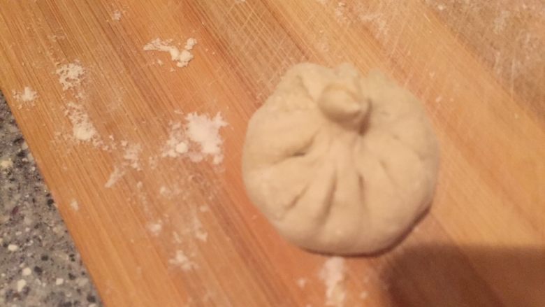 猪肉虾仁小笼包,慢慢捏住包子,中间揪掉。
