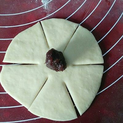 玫瑰面包,取一个面剂擀成圆皮,如图所示划六刀,中间不可划断,在中间部位放上馅料