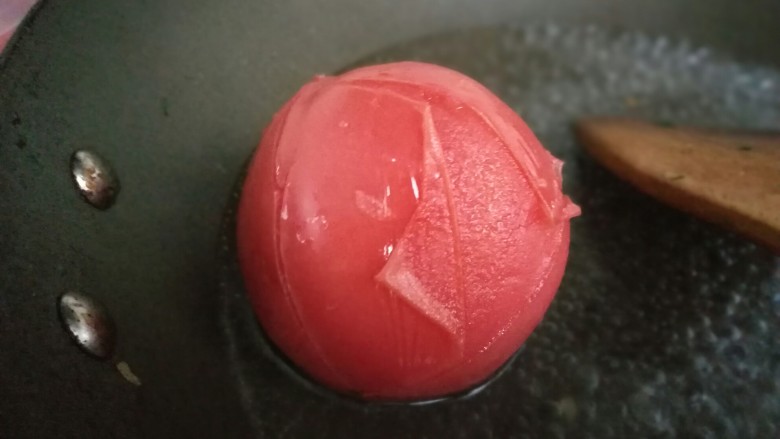 懒人料理番茄葱花炒饭,<a style='color:red;display:inline-block;' href='/shicai/ 3551'>西红柿</a>表皮划十字,开水中煮1-2分钟。待皮皱了即可捞出。