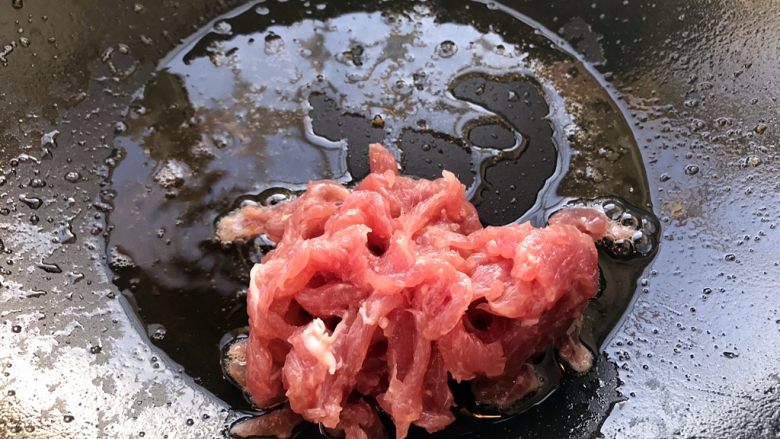 鱼香肉丝,坐锅倒油,把浆好的肉下锅