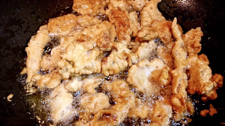锅包肉,所有肉片都炸好后,油锅继续加热,到7、8成热的时候,将所有的肉片一同倒入锅中二次煎炸