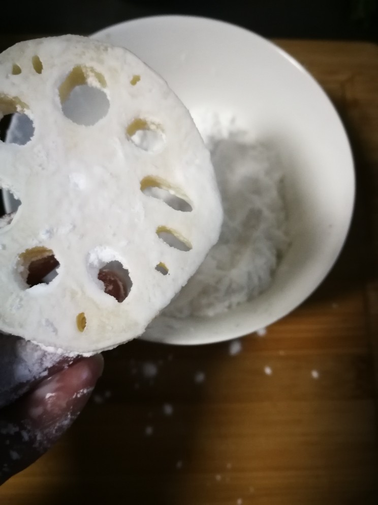 藕饼,准备生粉一碗,拿起一片藕片,最好用厨房用纸擦干一下,然后取生粉均匀地薄薄地拍一层在藕片两面,主要是吸干表面水份并且能让肉糜很好的吸附在藕片上(因为两手操作,拍照片有点难度,没有多拍,只能用文字诠释得仔细点😓)