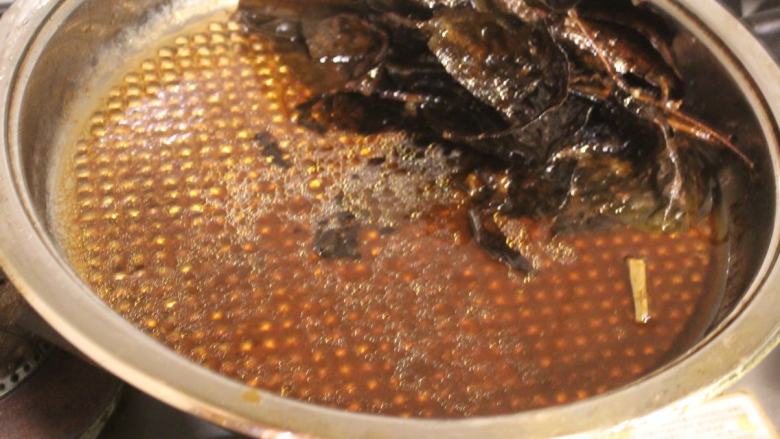 茄苳蒜头鸡,锅底的汤汁,是麻油、茄冬和鸡汁精华,可以再淋在鸡身上,也可以沾着鸡肉吃。淋饭也是很美味。