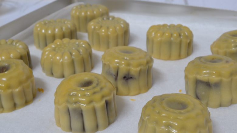 豆沙蛋黄月饼,取一蛋黄加少许清水拌匀,饼胚刷少许蛋黄水,烤箱预热180°烤10分钟,烤好后晾凉密封保存回油三天再食用