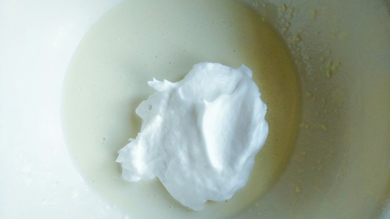 手把手交你怎样做酸奶溶豆,6.然后把取打好的蛋白2分之一放入酸奶糊里用翻拌的手法搅拌均匀,记得不要画圈圈哦,其实打好的蛋白不是那么容易消泡的。然后把余下的蛋白倒入进去继续搅拌均匀。接下来100度预热烤箱。