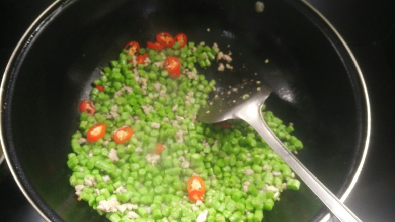 肉沫豆角丁,加入红椒粒翻炒,加入胡椒味精调味即可