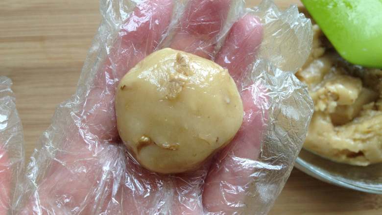 核桃酥,戴上一次性手套操作,取一小块面团(约20g),先搓圆,再稍稍用手按扁,厚薄看自己喜欢了