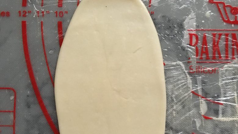 肉松麻薯蛋黄酥,取一个面团,收口朝上,用手掌压扁,用擀面杖对着面团的中间,朝上一次,朝下一次