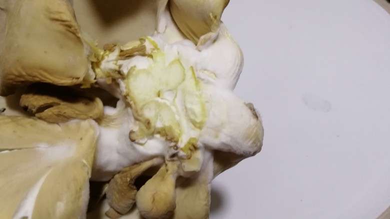 干炸鲜蘑,用剪刀剪去根部,洗的时候用清水快速的冲一下。