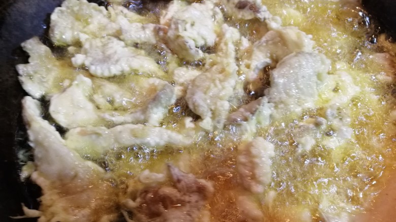 干炸鲜蘑,将裹上面糊的平菇,一个个放入锅里炸。