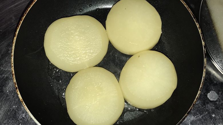 素之食谱—煎萝卜,取出萝卜在不粘锅里,有刀口的那面朝下,烙干水分后加油,中火煎1-2分钟