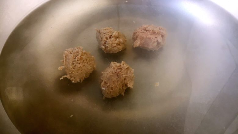 #懒人料理# 青萝卜丸子汤,锅里放入适量的水,水开后逐个放入小丸子,刚放入丸子时丸子沉底。