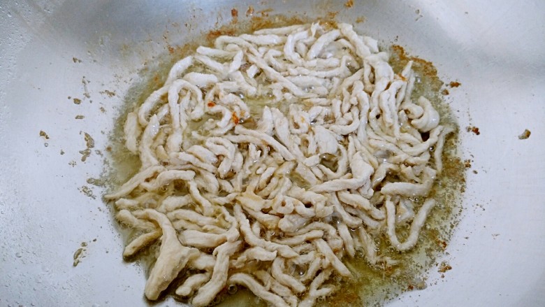 鱼香肉丝(川味版),待油七分热时放入肉丝煸炒至变色。