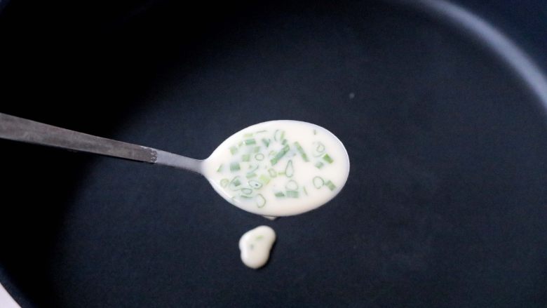 快手鸡蛋薄饼,平底锅不粘锅预热,舀入一小勺面糊;快速用勺底打转几圈;
