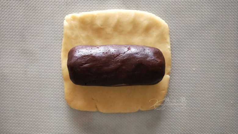 小熊爪印饼干--小盆友都喜欢,把大份的原味面团擀成方形,再将大份的可可面团塑形成相同长度的圆柱体。