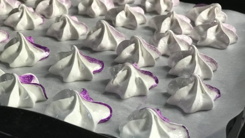 法式传统甜点：蛋白糖/Meringue,然后就最好玩的部分：开始挤出花型！ 挤到烤盘上的油纸上，大小要均匀，避免一会儿有熟的有糊的