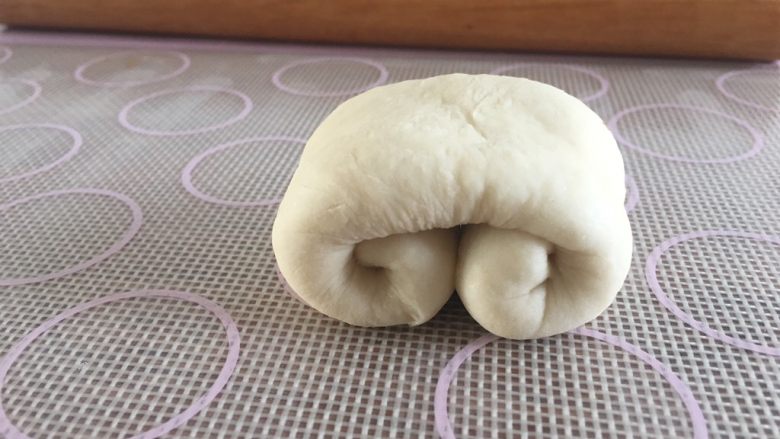 软萌面包卷(冷藏发酵),上下各自向中间卷起,保持两遍的厚度相同,卷到中间压紧;翻个面,造型完成;