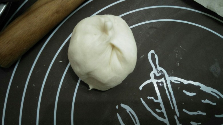 烧饼夹肉,两边切割面封好口,一个封口朝下,一个封口朝上,用手按压扁。