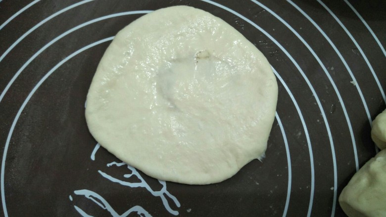 烧饼夹肉,稍微擀成圆型,在表面涂上一层水。