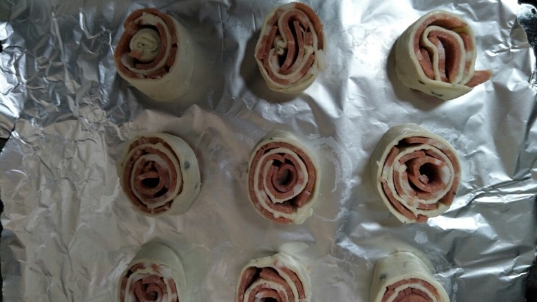 酥皮培根卷（飞饼皮版）,用刀切成小段放入铺了锡纸的烤盘上