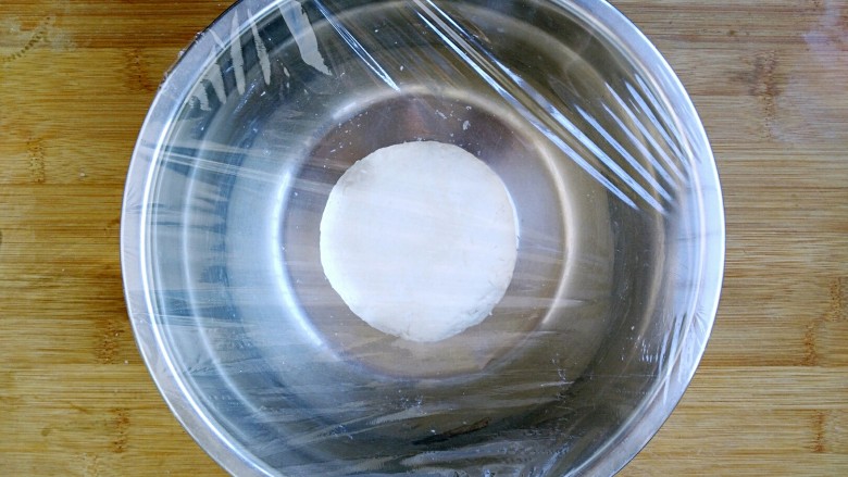 八寸披萨饼饼胚,盖上保鲜膜放在25℃左右的环境中发酵大约半小时,发酵至1.5到2倍大即可。