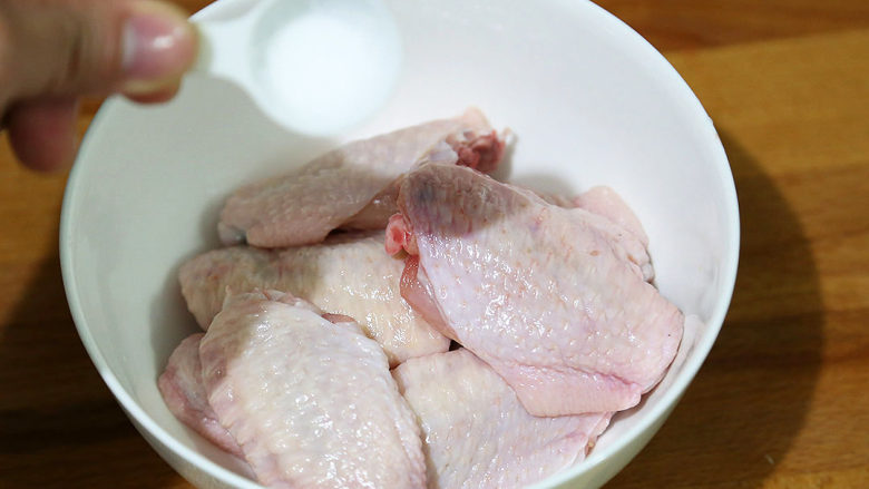 秘制可乐鸡翅,放入食盐,用手拌匀,腌制5分钟