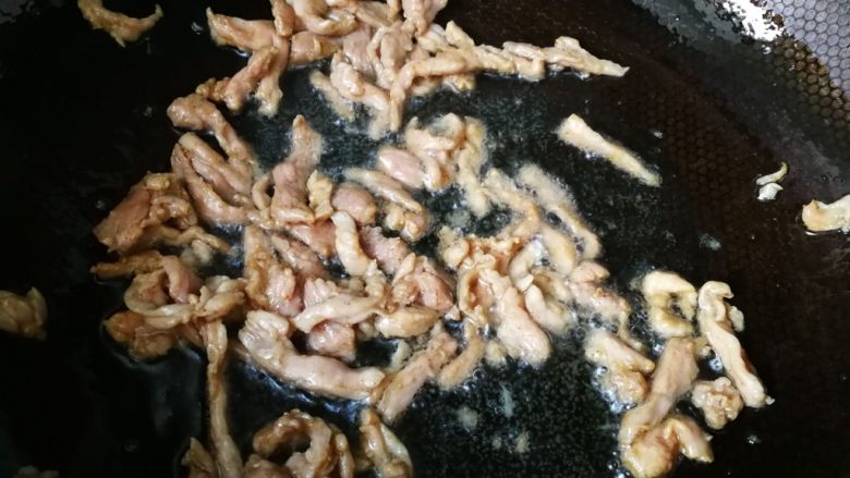 酸辣绿豆芽炒肉丝,中火偏大火些,快速把肉炒白,铲除备用。