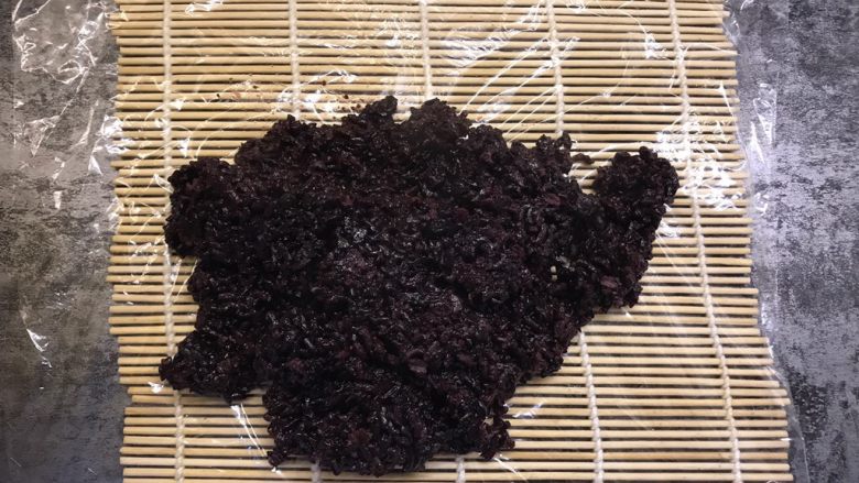 紫米粢饭团,寿司帘上铺上保鲜膜,将紫米放在保鲜膜上