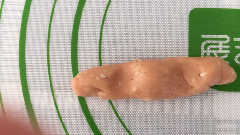 芝麻南乳饼干,取一小块,20g左右,搓成手指长的圆条,如图按两个坑