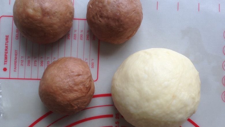 面包机版双味吐司,发酵好的面团,用手掌按压排气,可可面团分成3等份,全部滚圆,盖上保鲜膜静置15分钟
