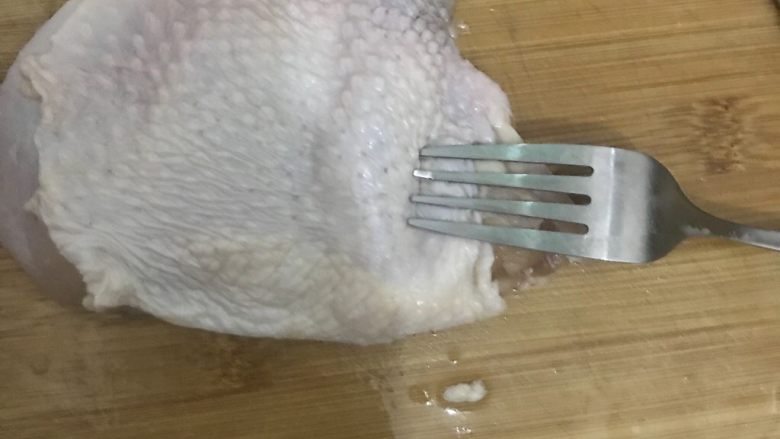 鸡排饭,将鸡皮一则翻过来用刀背敲打,使肉质松软,并用叉子在鸡皮上均匀的叉洞