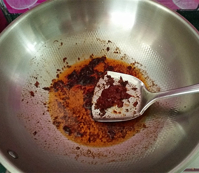 酱煮肥牛什锦锅,炒锅加热倒油,放入火锅调料及郫县豆瓣酱炒出红油