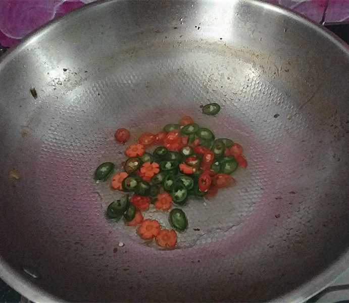 酱煮肥牛什锦锅,另起锅倒油、爆香青、红椒和胡萝卜片,趁热淋在砂锅中