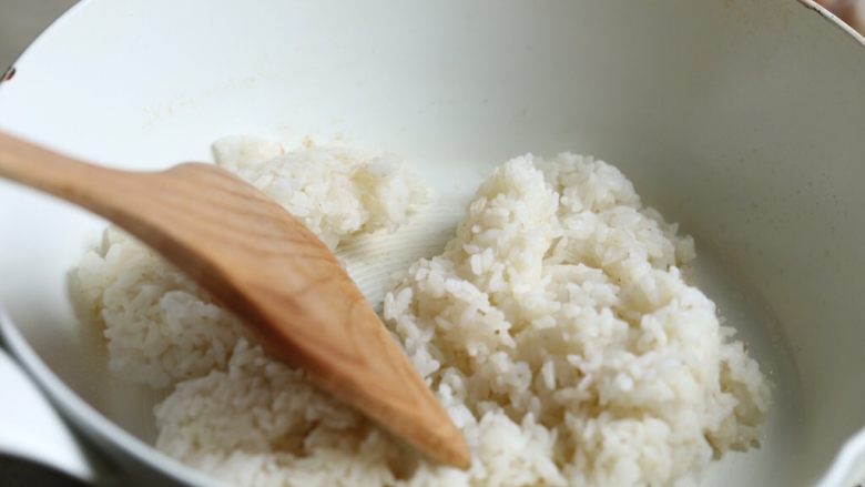 缤纷虾仁蛋炒饭,锅中加油烧热,中火,放入米饭翻炒,用铲在锅中打圈,将米饭打散,不要用铲切剁,米会切碎。