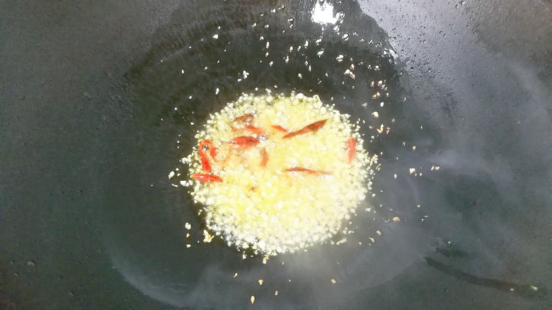 香菜拌海带丝,锅中入适量油,放入蒜蓉和干红辣椒煸出香味;