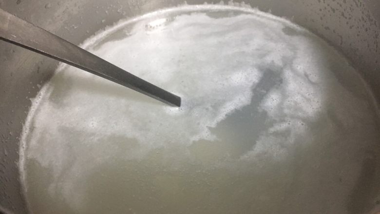#懒人料理# 三文鱼菌菇杂蔬粥,锅里放入水,水开了后放入大米,水再开后搅动一下米,避免粘锅,随后改小火煮20分钟。