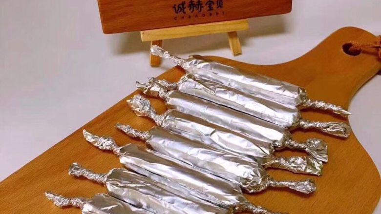 【宝宝菠菜鸡肉肠】12m+,将加肉泥挤到锡纸上面卷起、两侧拧紧。