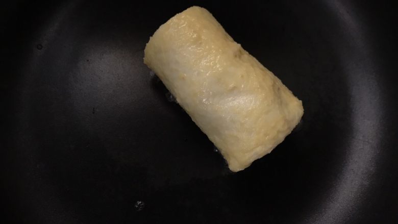 香蕉紫薯吐司卷,平底锅倒少于油,放入裹了蛋液的吐司卷,小火煎