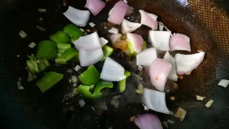 #懒人料理#红烧里脊肉条,热锅先爆香葱姜末,下入木耳,翻炒一两分钟,下入青椒,洋葱。再翻炒一两分钟。