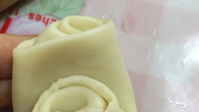 美味的蛋黄酥,松弛好的油酥皮,封口朝上,拇指由中间按下,然后四角朝中间折叠,用擀面杖轻轻擀压薄,豆沙蛋黄内馅放在油酥皮上面收紧口